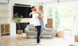© Louis-Paul Photo - Young couple moving in new home. Couple is having fun with cardboard boxes in new house at moving day.