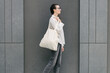© 4Max - Woman walking in the city with a white tote eco bag