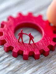 Poster - teamwork makes the dream work - two small figures on a large red gear symbolize collaboration, partn