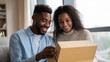 © Curioso.Photography - Smiling couple opening a cardboard box together, enjoying a home delivery or surprise gift.