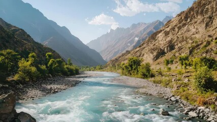 Poster - A clear mountain river flows rapidly between rocky slopes and lush greenery under a blue sky with scattered clouds.