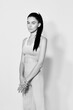 © SHOTPRIME STUDIO - Black and white portrait of a young woman sport fitness focused, wearing activewear with a calm expression and relaxed pose against a plain white background.