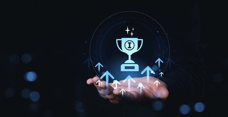 Poster - Hand holding glowing trophy icon with upward arrows representing success and achievement in futuristic digital style on dark background.
