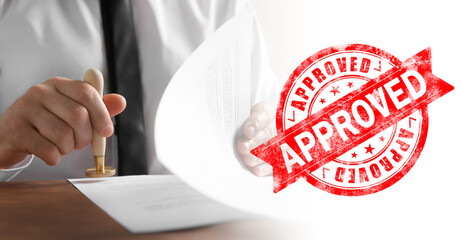 Fototapete - Man stamping document at desk and red stamp with word Approved. Banner design