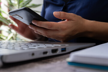 Poster - Woman's hands working on laptop and her cell phone