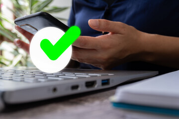 Poster - Woman's hands working on laptop and her cell phone with check mark icon with circle