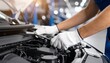 © photostockatinat - A car mechanic diligently repairing a car engine