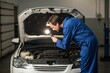 © abdelali - Auto Mechanic Inspecting Car Engine with Flashlight