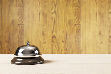 Poster - Classic service bell on wooden counter with blurred wood panel background in warm lighting, symbolizing hotel reception concept. 3D Rendering