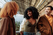 © bernardbodo - Group of young people talking and smiling in urban setting