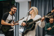 © qunica.com - A group of musicians rehearsing in a studio, featuring energetic interaction and focus. The scene includes guitars, a microphone, and drums, forming a cohesive and lively musical ensemble.