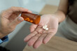 © Natee Meepian - Medication Dispensing. Healthcare worker pouring pills from bottle into patient hand.