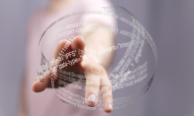 Fototapete - Close-up of a hand interacting with a digital hologram displaying lines of code and data.