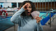 © Krakenimages.com - Middle-aged woman on a boat at a port holding mexican pesos with a surprised expression, blending excitement and intrigue in an outdoor maritime setting.