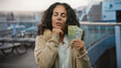 © Krakenimages.com - Romanian woman holding banknotes on a boat in a port, looking contemplative with lei currency visible, surrounded by an outdoor setting suggesting a financial or travel theme.