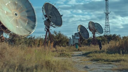 Poster - Group of satellite dishes installed in an open field, ready for use