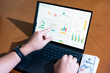 © josephchrist91 - A person is pointing at a laptop screen with a graph on it