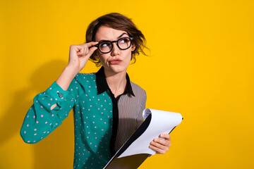 Poster - Photo of minded lovely nice woman wear stylish clothes hold contract look empty space isolated on yellow color background