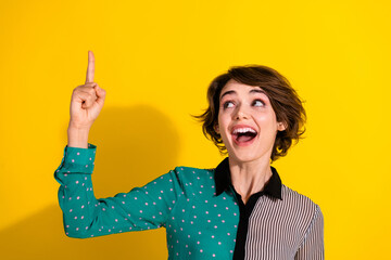 Poster - Photo of glad cheerful lovely girl wear stylish dotted print clothes look empty space isolated on yellow color background