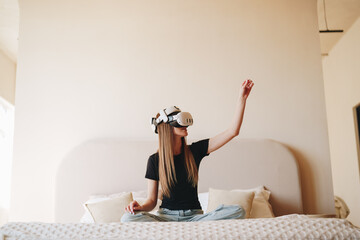 Poster - Young woman experiences virtual reality while sitting on a bed in a modern bedroom setting