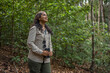 © Gino Tuesta - Female explorer birdwatching in the Amazon rainforest, using a binoculars