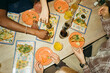 © Maskot - Directly above view of friends enjoying fresh tacos at fast food restaurant