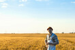 © Zoran Zeremski - Confident farmer standing in wheat field at sunset looking at camera.