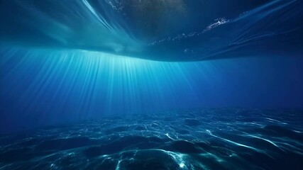Poster - Underwater ocean view with sunlight shining through water surface, creating light rays in deep blue sea environment.