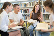 © JackF - Group of friendly students discuss books in the university library. They are preparing for exams together