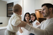 © asier - Happy family holding baby and smiling in kitchen