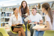 © JackF - In reading room of library, classmates sit in circle and chat nicely while preparing homework, talking and exchanging ideas..