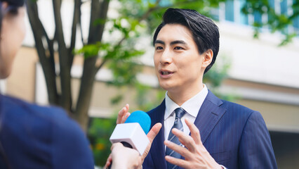 Poster - 街頭インタビューを受ける男性ビジネスパーソン