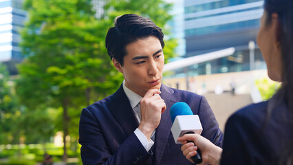 Leinwandbilder - インタビュー、記者会見、街頭、質問、考える、疑問、レポーター、取材、中継、テレビ、番組、ニュース、意見、政治家、主張、社長、不安、心配、不満、悩む、問題、トラブル、事件、アナウンサー、街角、都市、新緑、ビジネスマン、ビジネスパーソン、ビジネス、経営者、収録、VTR、街録、調査、リサーチ、若い、マイク、アンケート、口コミ、クチコミ、インタビュアー、突撃、疑惑、釈明、言い訳、男性、女性、日本人、人物