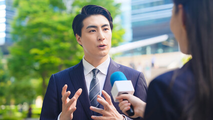 Poster - インタビュー、街頭、取材、テレビ、ニュース、口コミ、不満、クチコミ、記者、会見、感想、意見、男性、ビジネスマン、マイク、中継、レポーター、質問、屋外、笑顔、日本人、リポーター、アナウンサー、番組、TV、アンケート、調査、リサーチ、駅前、ビジネス、収録、新緑、都会、都市、会話、若い、歩行者、世論、VTR、報道、放送、宣伝、インタビュアー、CM、主張、マーケティング、説明、経営者、社長、人物