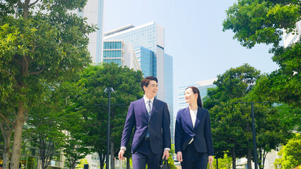 Poster - 新緑の街を歩く男女ビジネスパーソン