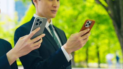 Poster - 新緑の街でスマホを使う男女ビジネスパーソン