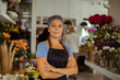 © Davor - Confident female florist standing in flower shop with arms crossed and smiling