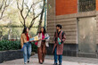 © Daniel Zapata/Stocksy - Smiling university students walking on campus.
