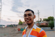© Hugo Fuentes/Stocksy - Wide angle portrait of an smiling man in colorful clothes.