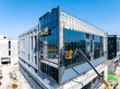 © ma yic/Stocksy - Construction Workers Installing Glass Windows on a Building