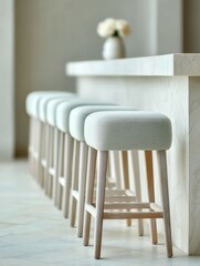 Poster - Minimalist upholstered bar stools with wooden legs lined up at modern marble counter in hotel lobby showcasing contemporary hospitality design and social space trends