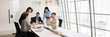 © fizkes - Group of professionals brainstorming gather in modern conference room, panoramic view. Team reviewing documents, exchanging ideas about strategic plan, project updates, or business decisions. Briefing