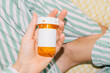 © Maryanne Gobble/Stocksy - Prescription medication bottle in hand