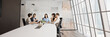 © fizkes - Five professionals engaged in discussion at conference table in contemporary design boardroom of skyscraper building office, panoramic view. Teamwork, decision-making, collaboration, planning strategy