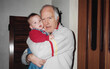 © María Soledad Kubat/Stocksy - Heartwarming 90s moment – grandfather and baby in arms