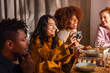 © VICTOR TORRES/Stocksy - Multi-ethnic friends gathering and taking photos during dinner