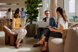 © BONNINSTUDIO/Stocksy - Formal businesspeople working together in modern office lobby