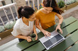 © BONNINSTUDIO/Stocksy - Two businesswomen working on laptop on balcony