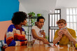 © BONNINSTUDIO/Stocksy - Diverse friends concentrating while playing cards at home