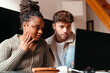 © Lucas Ottone/Stocksy - Multiracial couple at home looking at computer